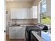 Laundry room featuring gray front load machines, white cabinets, and a window overlooking outdoor space at 4002 Bell Mountain Dr, Castle Rock, CO 80104