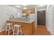 View of the kitchen and breakfast bar area featuring hardwood floors and stainless steel appliances at 9650 Huron St # 12, Thornton, CO 80260
