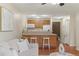 An open kitchen featuring a breakfast bar, hardwood floors, and modern decor with easy access to the living room at 9650 Huron St # 12, Thornton, CO 80260