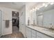 Bright bathroom featuring dual sinks, granite countertops, and a walk-in closet at 5201 Lumos Ln, Castle Rock, CO 80104