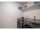 Laundry room with gray front load washer and dryer, and storage shelving at 5201 Lumos Ln, Castle Rock, CO 80104