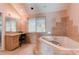 Elegant bathroom featuring a soaking tub and a vanity with natural light at 10291 E Powers Ave, Greenwood Village, CO 80111