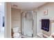 Full bathroom with a glass-enclosed shower and toilet, accented by a dark purple towel at 10291 E Powers Ave, Greenwood Village, CO 80111