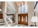 Bright foyer featuring high ceilings, chandelier, staircase, and large front door with decorative glass panels at 10291 E Powers Ave, Greenwood Village, CO 80111