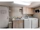 Functional laundry room equipped with a washer, dryer, sink, and ample cabinet space at 10291 E Powers Ave, Greenwood Village, CO 80111