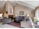 Inviting living room featuring a vaulted ceiling, fireplace, comfortable seating, and natural light at 10291 E Powers Ave, Greenwood Village, CO 80111