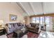 Comfortable living room with vaulted ceilings, a cozy seating area, and a large window overlooking the outdoors at 10291 E Powers Ave, Greenwood Village, CO 80111