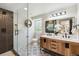 Modern bathroom featuring double sink vanity, large mirror, and glass enclosed shower with stylish tiles at 6330 E Irwin Pl, Centennial, CO 80112
