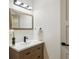Modern powder room featuring a wood vanity, stylish mirror, and sleek fixtures at 6330 E Irwin Pl, Centennial, CO 80112