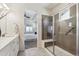 Bathroom with tiled glass shower featuring a seat and a view into the bedroom at 12597 W Big Horn Cir, Broomfield, CO 80021