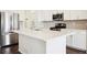 Modern kitchen with white cabinets and large island at 12597 W Big Horn Cir, Broomfield, CO 80021