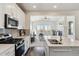 Contemporary kitchen with stainless steel appliances, white cabinetry, and an open view to the living area at 12597 W Big Horn Cir, Broomfield, CO 80021