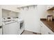 Bright laundry room featuring white appliances, a gray tile floor, and a granite counter top at 12597 W Big Horn Cir, Broomfield, CO 80021