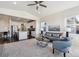 Open concept living room flowing to the kitchen with island seating, with plush grey couches and an airy feel at 12597 W Big Horn Cir, Broomfield, CO 80021