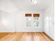 Sun-lit bedroom featuring hardwood floors, two large windows, and built-in closets at 4363 N Raleigh St, Denver, CO 80212