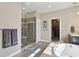 Bright bathroom featuring a stand-alone shower, soaking tub, and walk-in closet at 15961 Lookout Pt, Broomfield, CO 80023