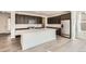 Modern kitchen with a large island, quartz countertops, stainless steel appliances, and dark wood cabinets at 4600 Thistle Dr, Brighton, CO 80601