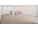 Spacious loft with modern railings, carpeted floor and three windows at 4600 Thistle Dr, Brighton, CO 80601