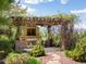 Outdoor living space features a stone fireplace, pergola, and lush landscaping, creating a private oasis at 10370 Grande Vista Ct, Lone Tree, CO 80124