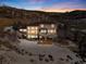 Beautiful stone home with large windows on a hill with snow and an outdoor living area with a fire pit at 10370 Grande Vista Ct, Lone Tree, CO 80124