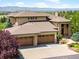 Gorgeous home with a three-car garage, stone accents, and landscaped front yard at 10370 Grande Vista Ct, Lone Tree, CO 80124