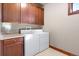 Laundry room featuring tile countertop, wood cabinets, washer, and dryer at 10370 Grande Vista Ct, Lone Tree, CO 80124