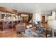 Open living room with hardwood floors, a full bar, and a cozy seating area with leather chairs at 10370 Grande Vista Ct, Lone Tree, CO 80124