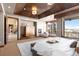Luxurious main bedroom featuring tray ceiling, seating area, and scenic views at 10370 Grande Vista Ct, Lone Tree, CO 80124