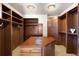 Spacious walk-in closet with custom wood shelving, center island, and ample storage space at 10370 Grande Vista Ct, Lone Tree, CO 80124