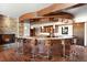 Elegant wet bar with pendant lighting, seating for six, stone accents, and wooden cabinetry at 10370 Grande Vista Ct, Lone Tree, CO 80124