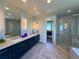 Bright bathroom with a double vanity, modern fixtures, and glass shower, with an adjacent walk-in closet at 3125 Red Kit Rd, Franktown, CO 80116