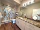 Well-lit bathroom featuring granite counters, modern fixtures, a tiled shower, and a framed mirror at 3125 Red Kit Rd, Franktown, CO 80116
