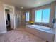 Relaxing bathroom featuring a soaking tub, a separate glass shower, and a view of the landscape at 3125 Red Kit Rd, Franktown, CO 80116