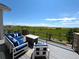 Relaxing outdoor deck with plush seating, a fire table, and scenic views of the surrounding green landscape at 3125 Red Kit Rd, Franktown, CO 80116
