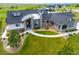 Aerial view of a modern home with stone accents, a circular driveway, and beautifully landscaped grounds at 3125 Red Kit Rd, Franktown, CO 80116