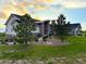 Charming front exterior featuring stone accents, attractive landscaping, and a well-maintained lawn at 3125 Red Kit Rd, Franktown, CO 80116