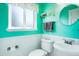 Charming half-bathroom featuring bright teal walls, white wainscoting, and stylish modern fixtures at 978 Mercury Cir, Lone Tree, CO 80124