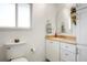 Bright bathroom with a white vanity, toilet, and decorative mirror with plant at 978 Mercury Cir, Lone Tree, CO 80124