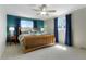 Spacious bedroom with a ceiling fan, large windows and blue curtains and accent wall at 978 Mercury Cir, Lone Tree, CO 80124