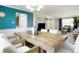 Dining area featuring a rustic wood table, white slip-covered chairs, and seamless transition to living room at 978 Mercury Cir, Lone Tree, CO 80124
