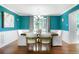 Bright dining room with teal walls, a stylish chandelier, and a large window bringing in natural light at 978 Mercury Cir, Lone Tree, CO 80124