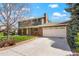Two-story home featuring a brick and gray siding exterior, a two-car garage, and a well-manicured front yard at 978 Mercury Cir, Lone Tree, CO 80124