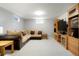 Basement living room with large sectional sofa, television, and hardwood entertainment center at 978 Mercury Cir, Lone Tree, CO 80124