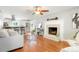 Bright living room with hardwood floors, fireplace, and open access to a modern kitchen with breakfast bar at 978 Mercury Cir, Lone Tree, CO 80124