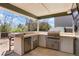 Covered patio featuring a built-in barbecue, counter, and cabinetry with refrigerator at 978 Mercury Cir, Lone Tree, CO 80124