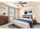 Relaxing bedroom with a ceiling fan, a large window, wooden furniture, and a bed with blue accents at 155 S Pennsylvania St # 311, Denver, CO 80209