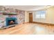 Bright living room with hardwood flooring, a brick fireplace with blue tiles, and a wooden front door at 155 S Pennsylvania St # 311, Denver, CO 80209