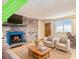 Comfortable living room features a brick fireplace with a mounted television and bright window at 155 S Pennsylvania St # 311, Denver, CO 80209