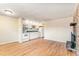 Spacious living room with hardwood floors, an open kitchen with white appliances, and a brick fireplace feature at 155 S Pennsylvania St # 311, Denver, CO 80209