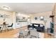 Inviting living room with hardwood floors, a brick fireplace, and an open kitchen layout with white cabinets at 155 S Pennsylvania St # 311, Denver, CO 80209